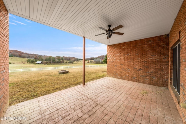 view of patio / terrace featuring a rural view, fence, and a ceiling fan