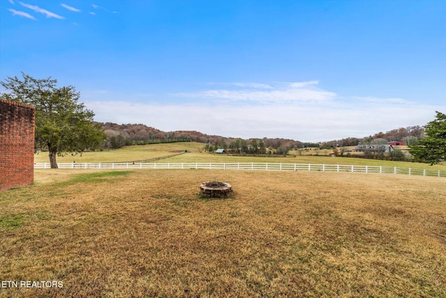 view of yard with fence and a rural view