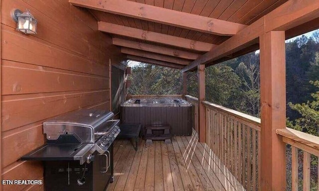 wooden terrace with area for grilling and a hot tub