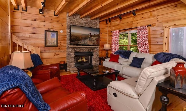 living area with wood ceiling, wooden walls, and beam ceiling