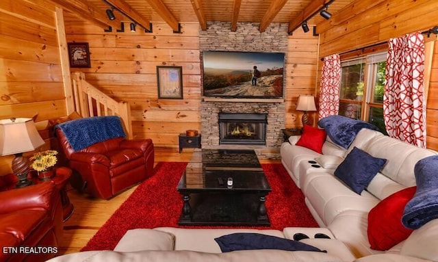 living area with a fireplace, wood ceiling, wood walls, wood finished floors, and beamed ceiling