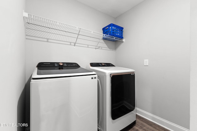 laundry room with dark wood-style flooring, laundry area, washer and clothes dryer, and baseboards