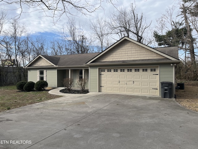 ranch-style home with driveway, central AC, and a garage