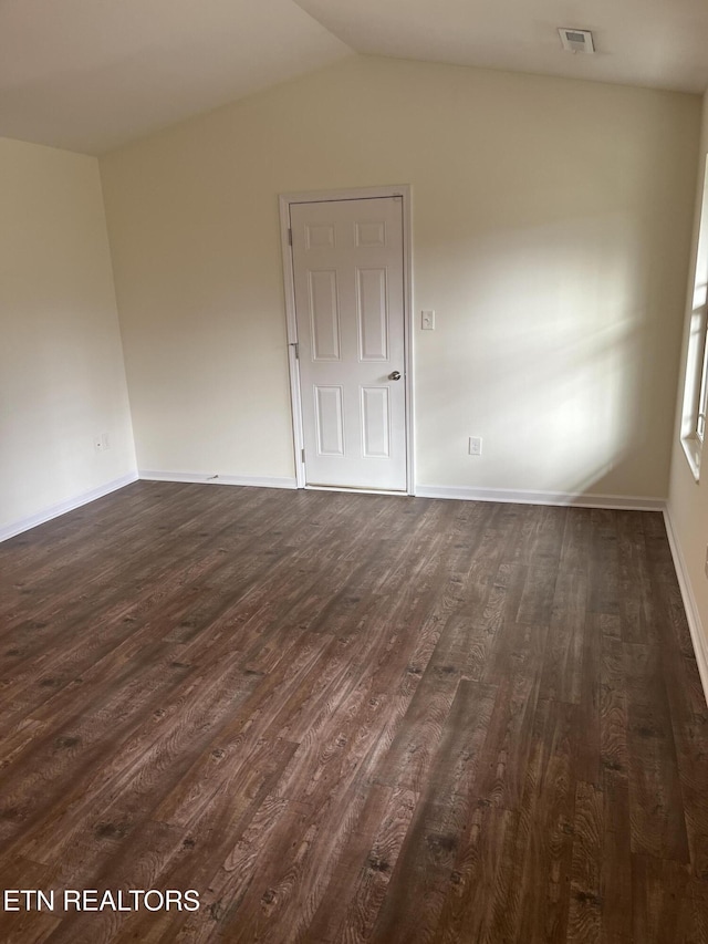 unfurnished room with visible vents, baseboards, dark wood-type flooring, and lofted ceiling