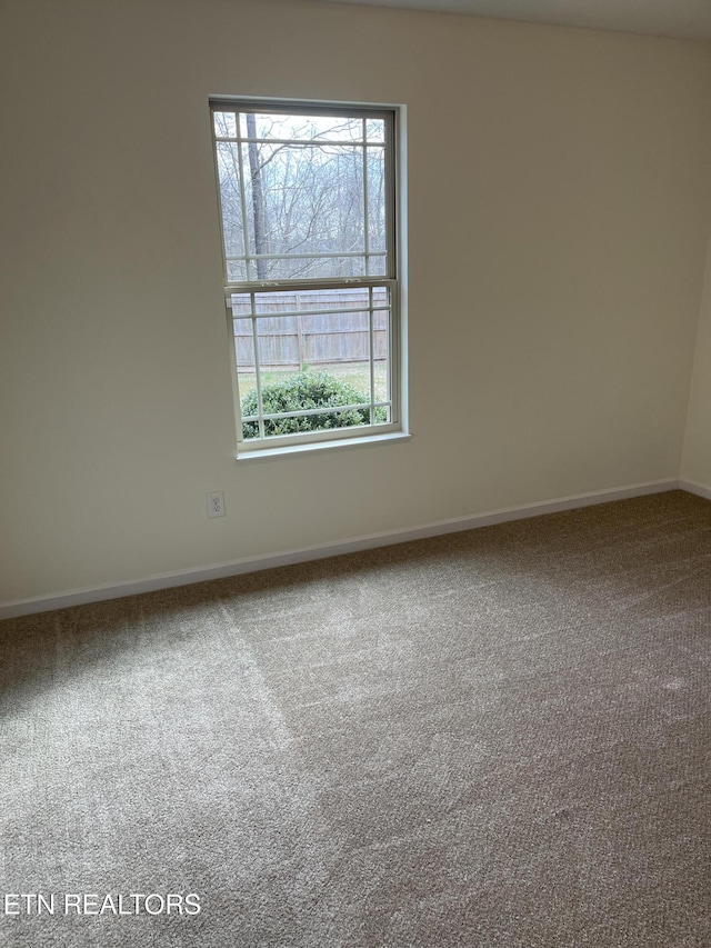 carpeted spare room with baseboards