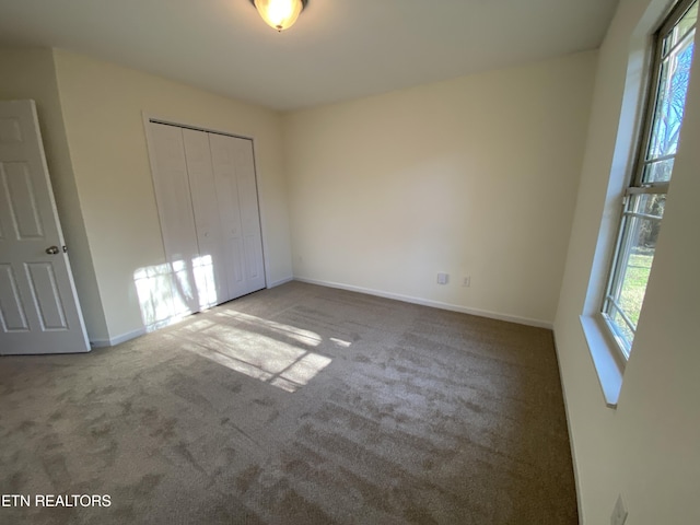 unfurnished bedroom featuring a closet, baseboards, and carpet floors