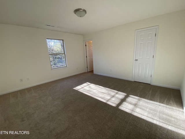 unfurnished room featuring visible vents, carpet, and baseboards