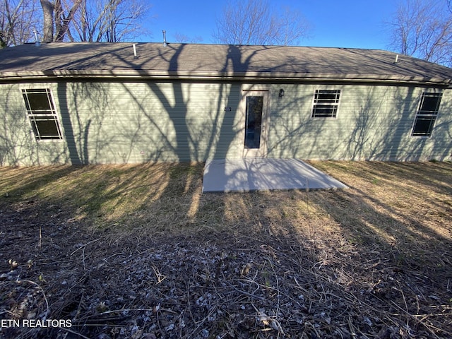 back of house with a patio area, brick siding, and a shingled roof