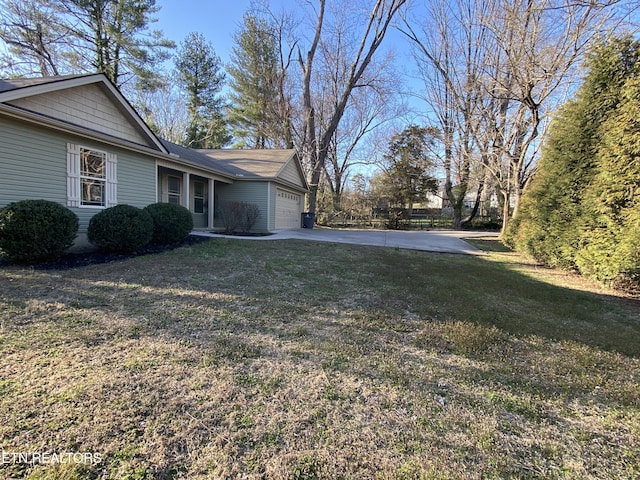 view of yard featuring a garage and driveway