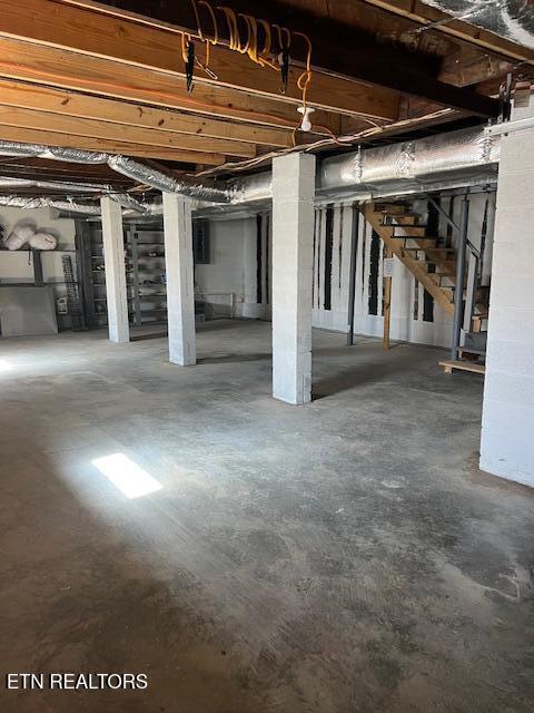 unfinished basement featuring stairway