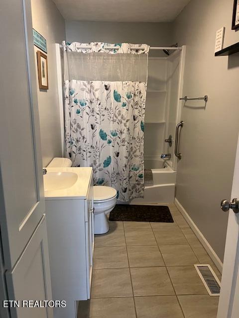 bathroom featuring baseboards, visible vents, toilet, shower / tub combo with curtain, and vanity