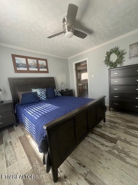 bedroom featuring crown molding, a textured ceiling, ceiling fan, and hardwood / wood-style floors