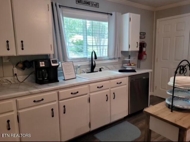 kitchen featuring dishwashing machine, a sink, white cabinets, light countertops, and crown molding