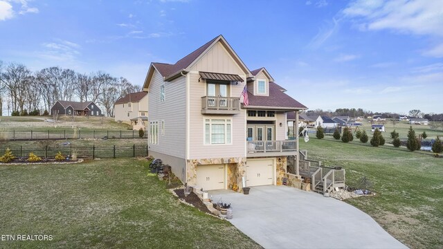 view of front of property with a front yard, concrete driveway, stairway, and an attached garage