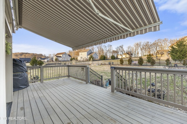 wooden deck featuring a fenced backyard, a residential view, and a yard