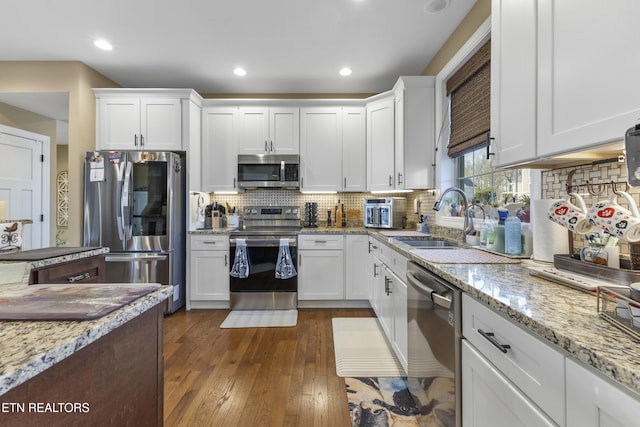 kitchen with white cabinets, stainless steel appliances, and dark wood-type flooring