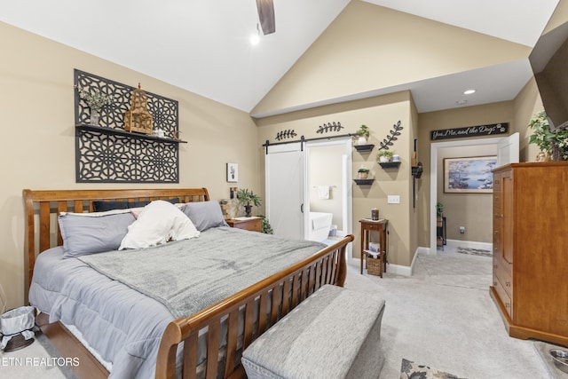 bedroom featuring a barn door, light carpet, ensuite bath, high vaulted ceiling, and baseboards