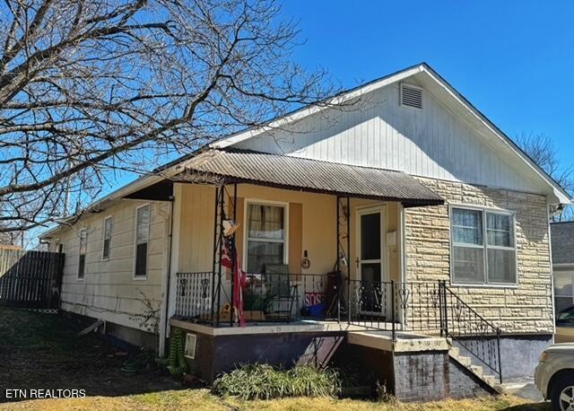 view of front of home with covered porch and stone siding