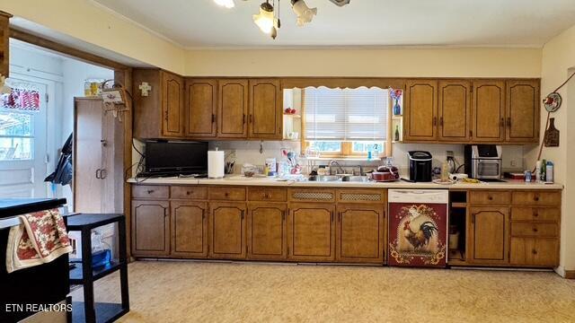 kitchen with brown cabinetry, light countertops, and dishwasher