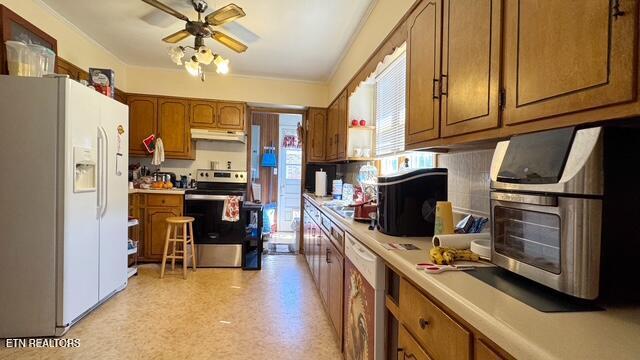 kitchen featuring under cabinet range hood, white appliances, light countertops, brown cabinets, and light floors