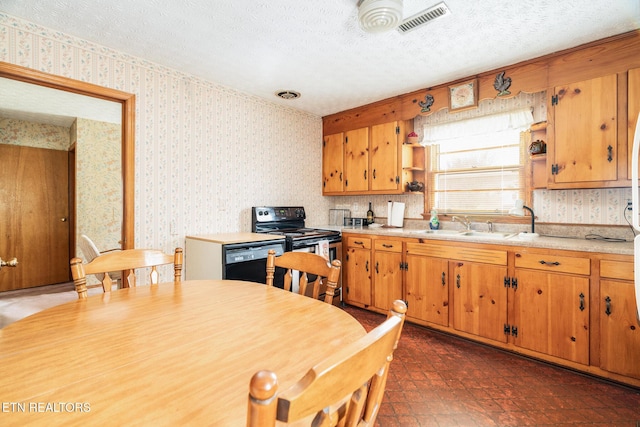 kitchen with light countertops, visible vents, a textured ceiling, black appliances, and wallpapered walls