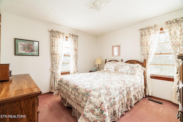 bedroom with carpet floors, visible vents, and baseboards