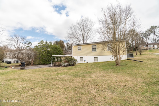 back of house with a yard, cooling unit, and driveway