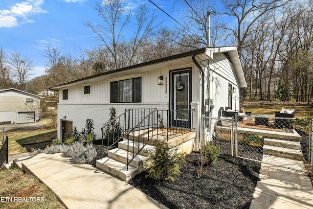 view of front of property featuring a gate, fence, and brick siding