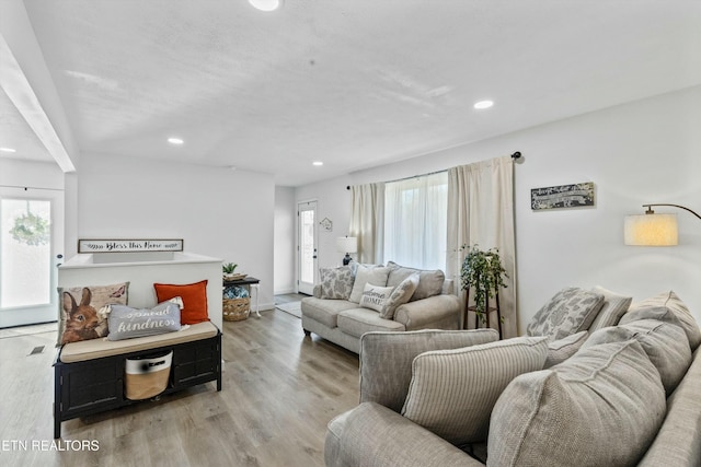 living area featuring light wood-type flooring, a wealth of natural light, and recessed lighting