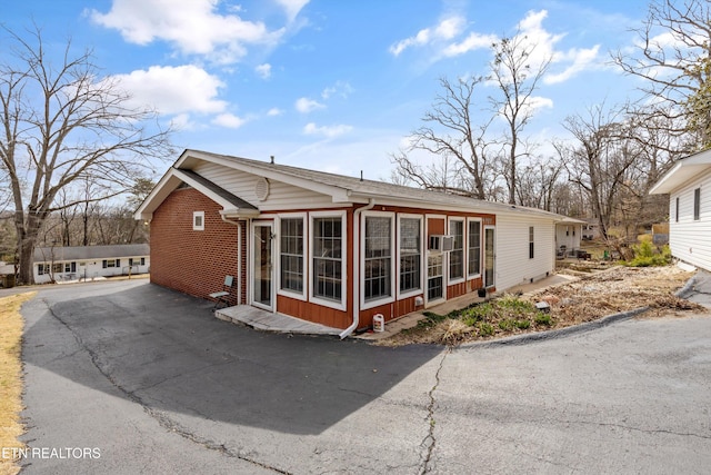 view of side of home with a sunroom and brick siding