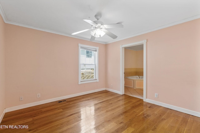 unfurnished bedroom featuring light wood-style floors, baseboards, visible vents, and crown molding