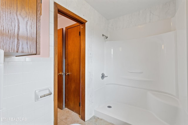 bathroom with walk in shower, tile walls, and tile patterned floors