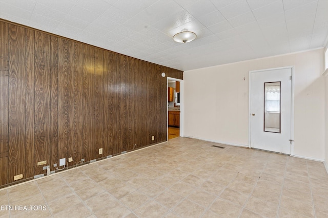 spare room featuring visible vents and wooden walls