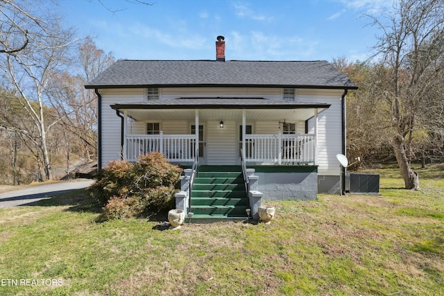 bungalow-style house with a chimney, a porch, roof with shingles, stairs, and a front lawn