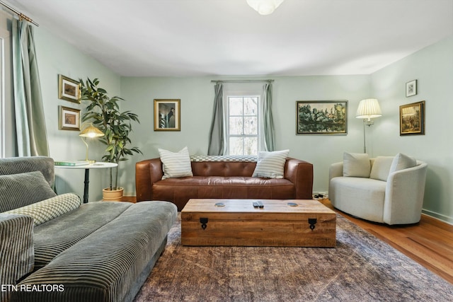 living area featuring baseboards and wood finished floors