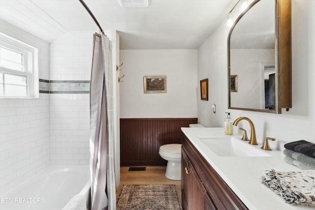 bathroom with visible vents, toilet, a wainscoted wall, wood finished floors, and vanity