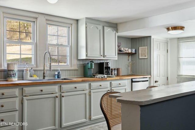 kitchen featuring a sink, butcher block countertops, open shelves, and dishwasher