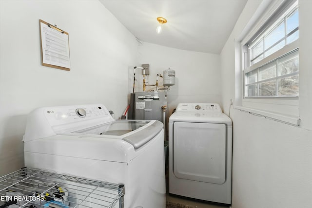 laundry room with laundry area, water heater, and washer and clothes dryer