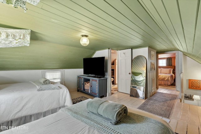 bedroom with lofted ceiling, wooden ceiling, and wood finished floors