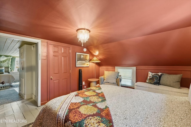 bedroom featuring vaulted ceiling and an inviting chandelier