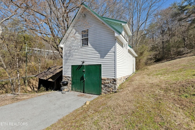 view of property exterior featuring stone siding and a yard