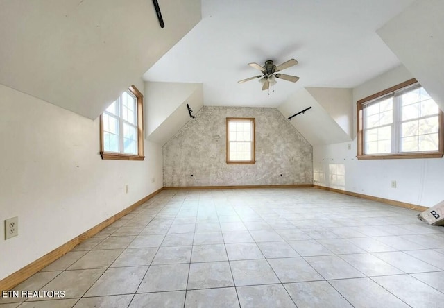 bonus room with a ceiling fan, vaulted ceiling, plenty of natural light, and baseboards