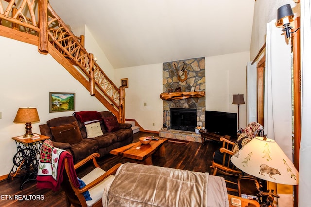 living area featuring a stone fireplace, stairway, wood finished floors, and baseboards