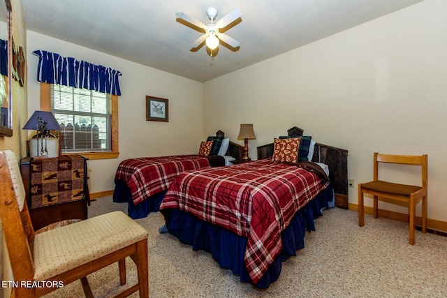 carpeted bedroom with ceiling fan and baseboards