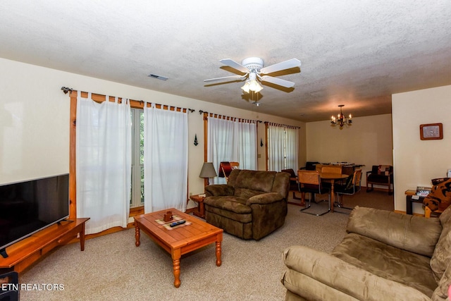 living area with carpet, visible vents, a textured ceiling, and ceiling fan with notable chandelier