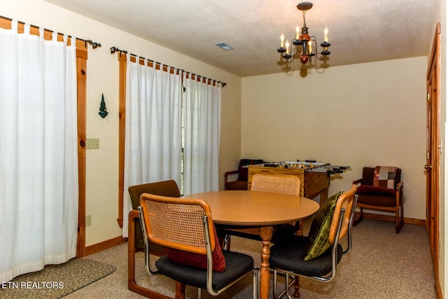 dining room with a chandelier, carpet floors, and baseboards