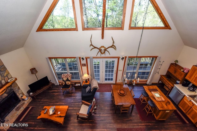 living room featuring high vaulted ceiling, a fireplace, and wood finished floors