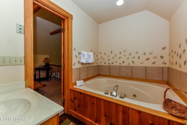 full bath with vaulted ceiling, a tub with jets, and vanity