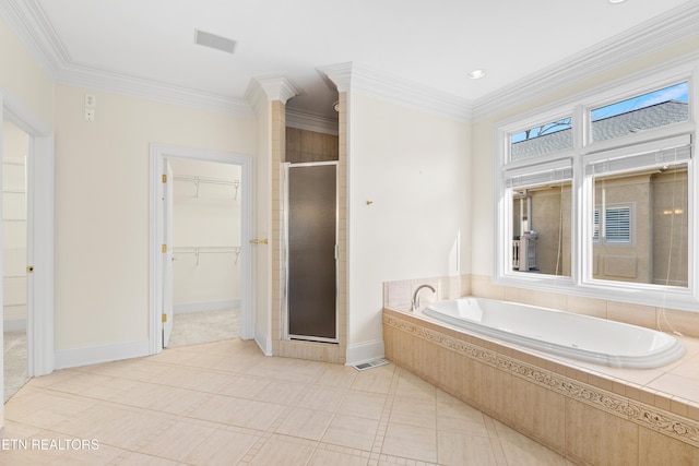 bathroom with baseboards, ornamental molding, a shower stall, a bath, and a walk in closet