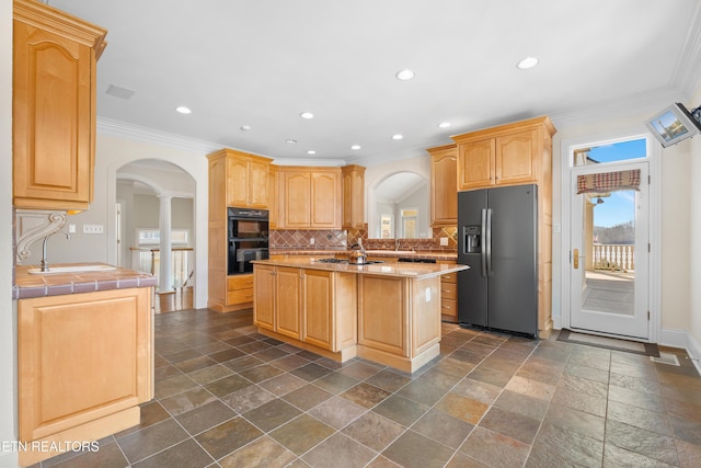 kitchen featuring decorative backsplash, arched walkways, light brown cabinets, and black appliances